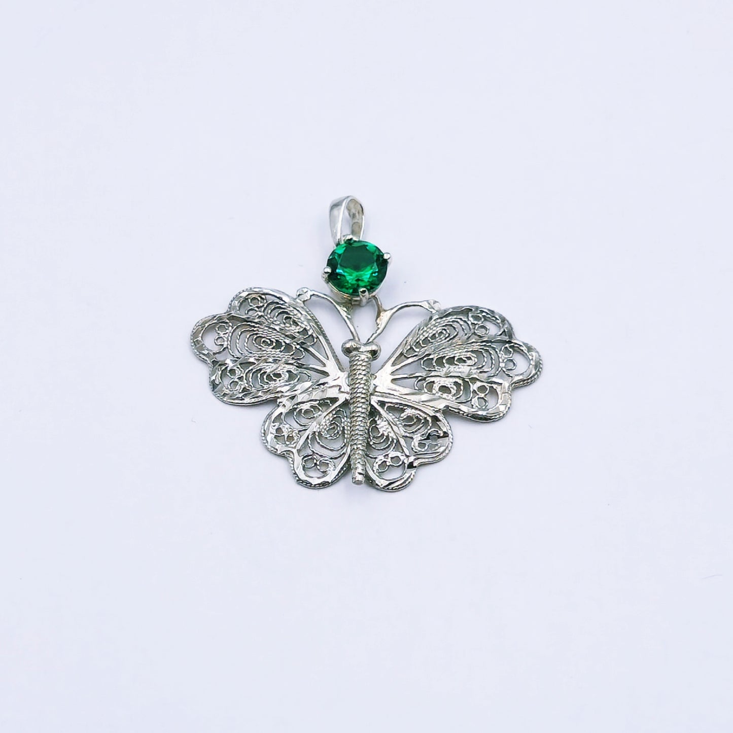 Sterling silver butterfly pendant with intricate filigree detailing and a central green cubic zirconia, approx. 3.4cm wide by 2.6cm high, weighing 3.0g
