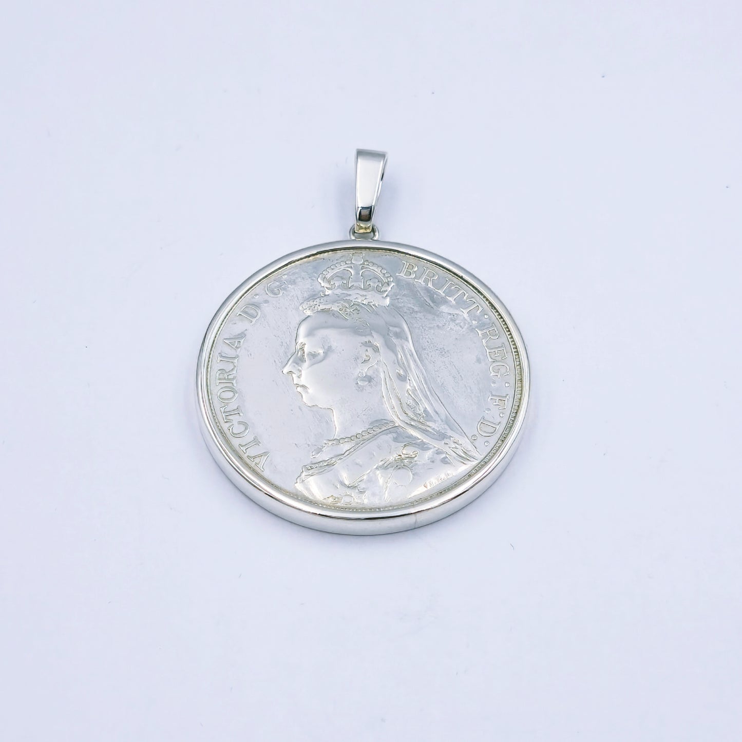Sterling silver pendant featuring an 1889 Queen Victoria coin, set in a silver frame with a 4cm diameter loop, weighing approximately 32.1g