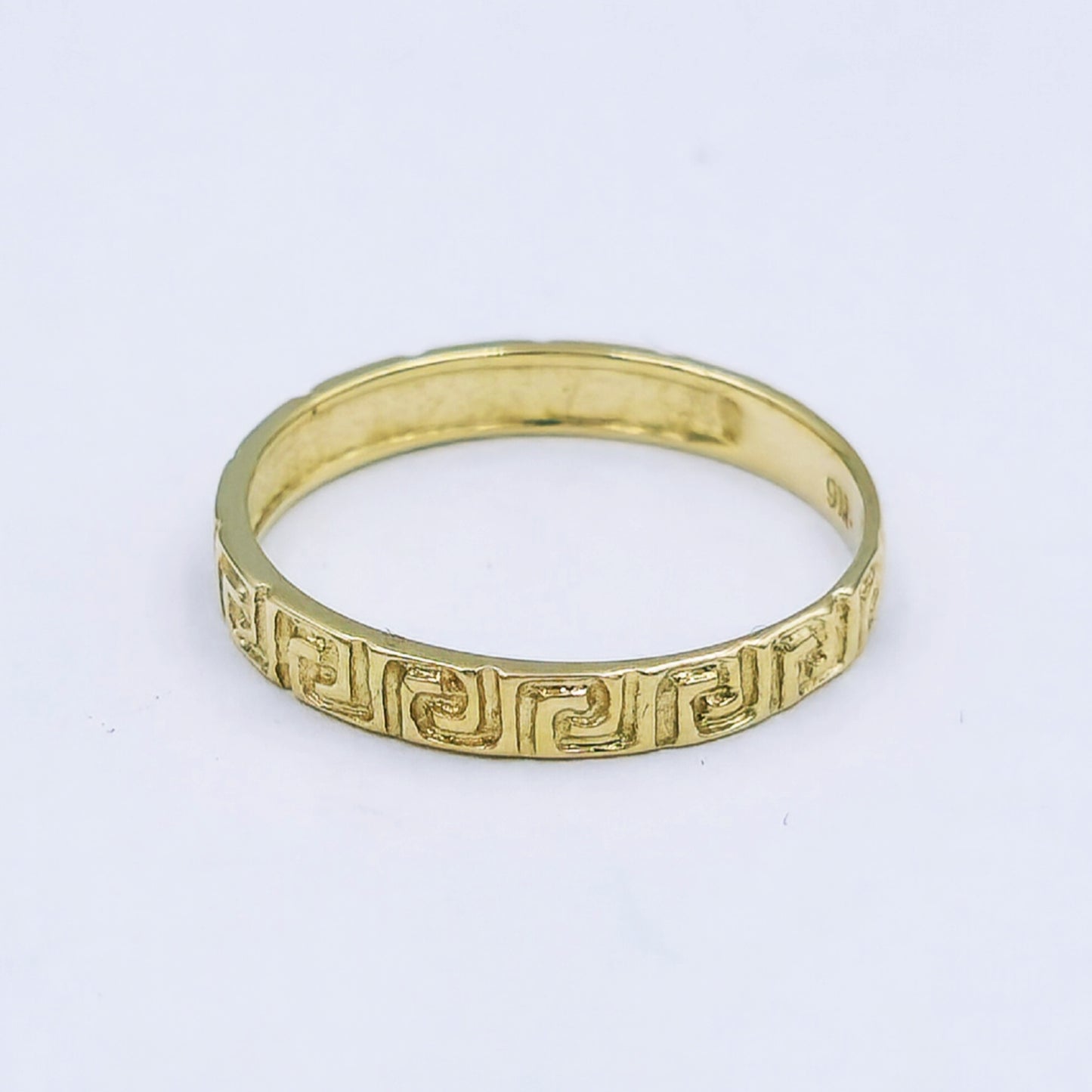 9ct yellow gold band with engraved Greek key design, 2.5mm wide, ring size L½, weighing approximately 1.1g.