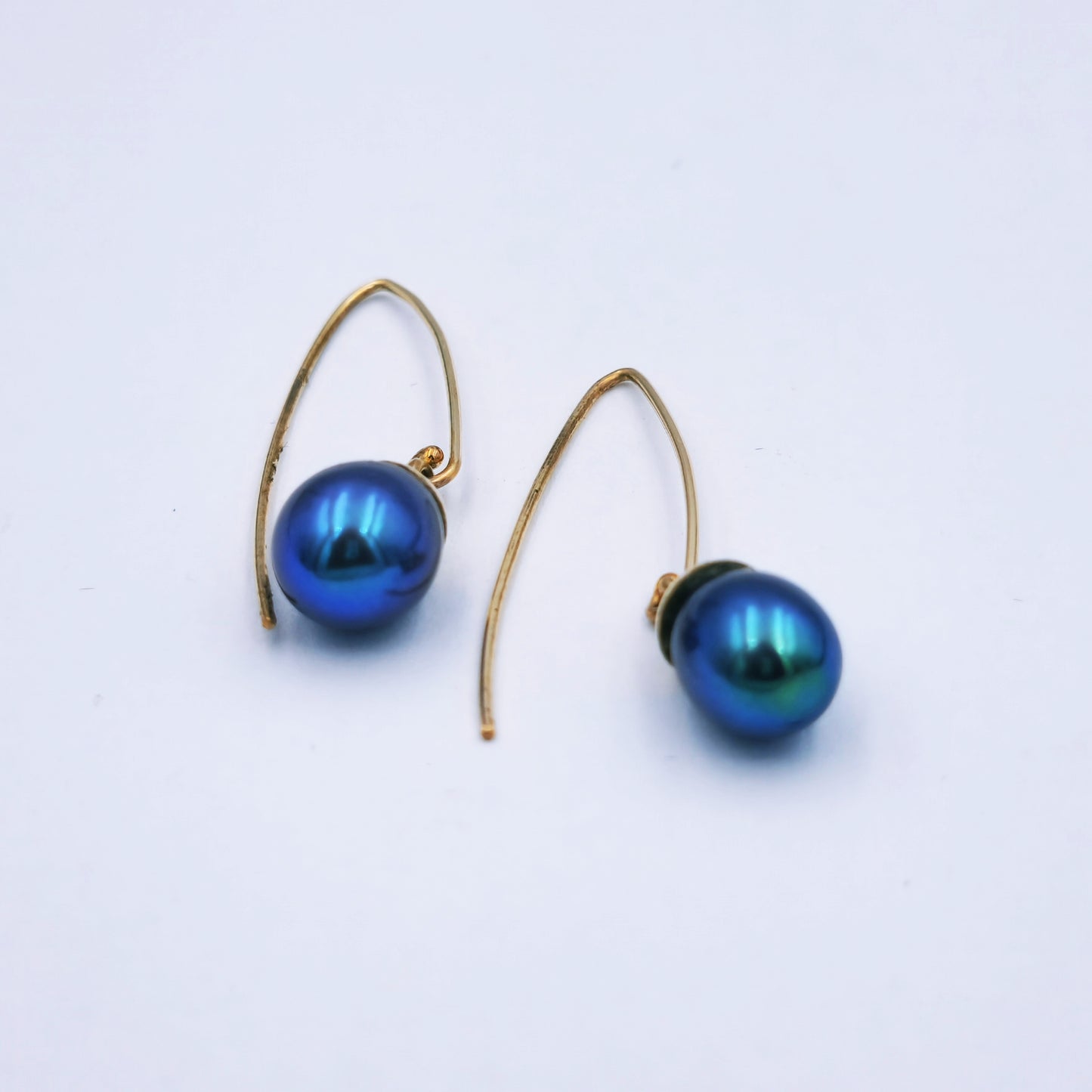 Pair of 9ct yellow gold drop earrings featuring 9mm peacock blue/grey pearls on long shepherd hooks; total length approx. 3cm.