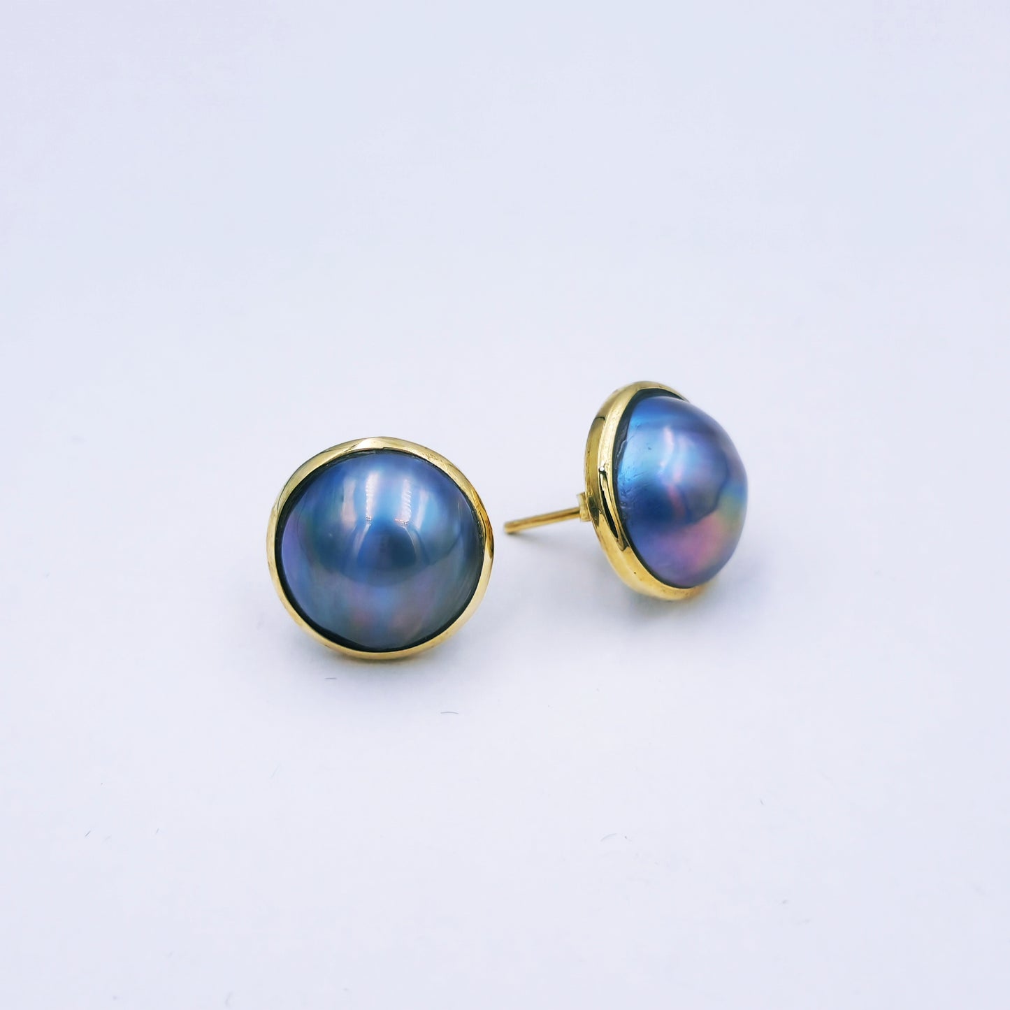 Pair of 9ct yellow gold stud earrings with round peacock blue/grey marbe pearls (12mm diameter) in classic gold frames with butterfly backs.