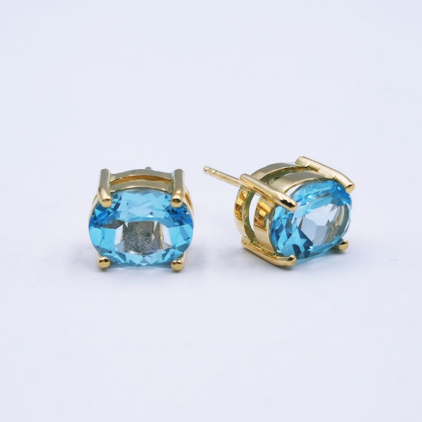 Pair of 9ct yellow gold stud earrings with large oval sky blue topaz (approx. 9mm x 7mm) in classic four-claw settings; approx. 2.5g total weight.