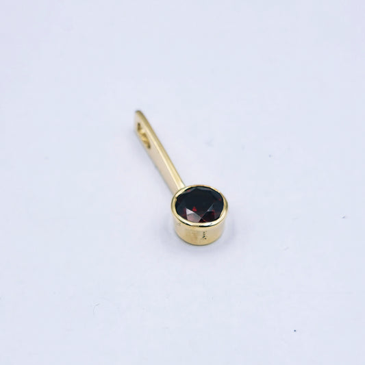 9ct yellow gold pendant with a single 5mm round garnet set in a tube at the end of a slim polished bar, approx. 1.2g