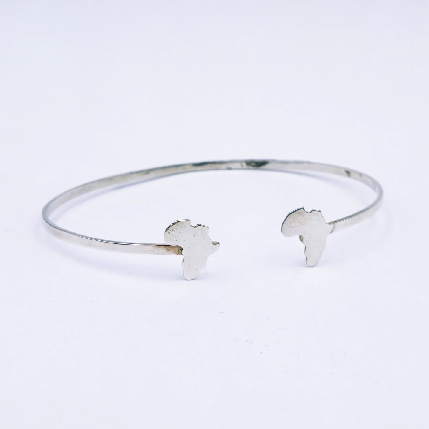 Sterling silver open bangle featuring cut-out Africa shapes at each end, 65mm adjustable diameter