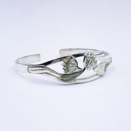 Silver bracelet with protea design on a white background