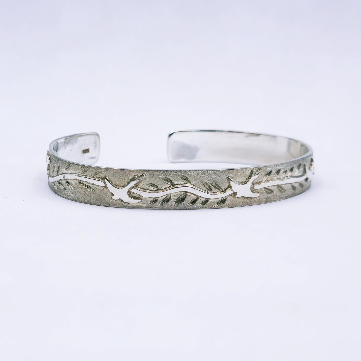 Sterling silver C-shape bangle featuring cut-out swallows and engraved leaves, handmade with 65mm diameter and 10mm width.