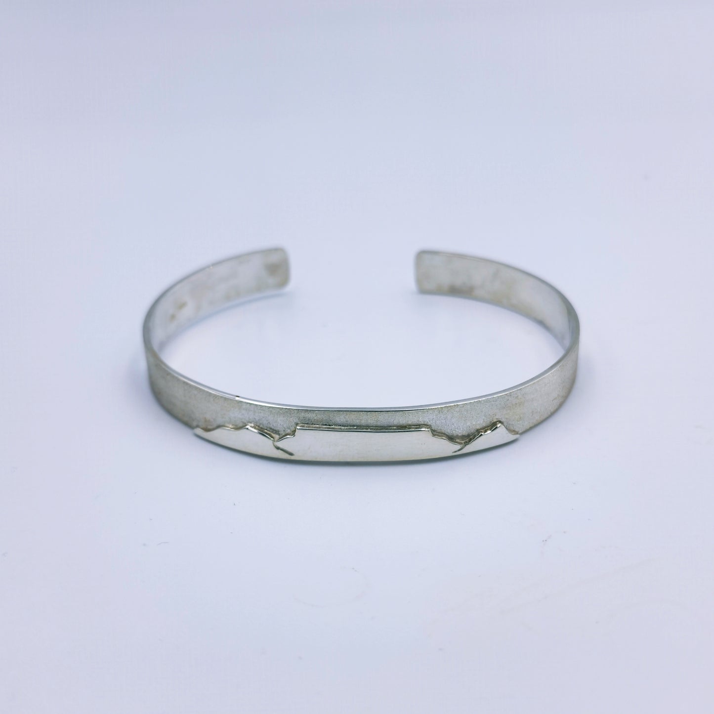 Ladies handmade sterling silver C-shaped bangle with Table Mountain motif and matte finish, 66mm diameter, 8mm wide