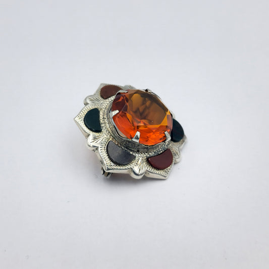 Sterling silver Scottish flower brooch with agate, jasper, and bloodstone in the petals, and a large 15mm round amber-toned Cairngorm gemstone in the centre; approx. 6.4g