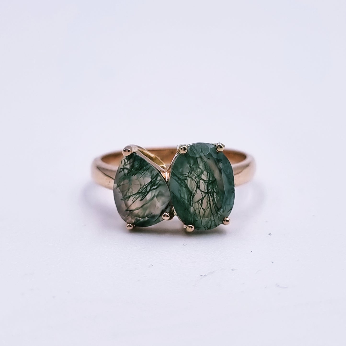 9ct rose gold ring featuring an oval (9mm x 7mm) and pear-shaped (8mm x 6mm) moss agate in a modern claw setting; total weight approx. 3.3g; Size M.
