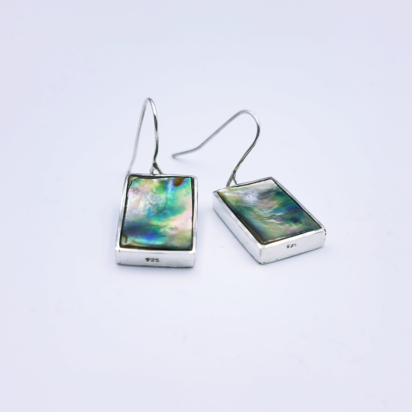 Free-form sterling silver pendant with natural abalone shell from the Eastern Cape, showing iridescent blues and greens with a silver frame.