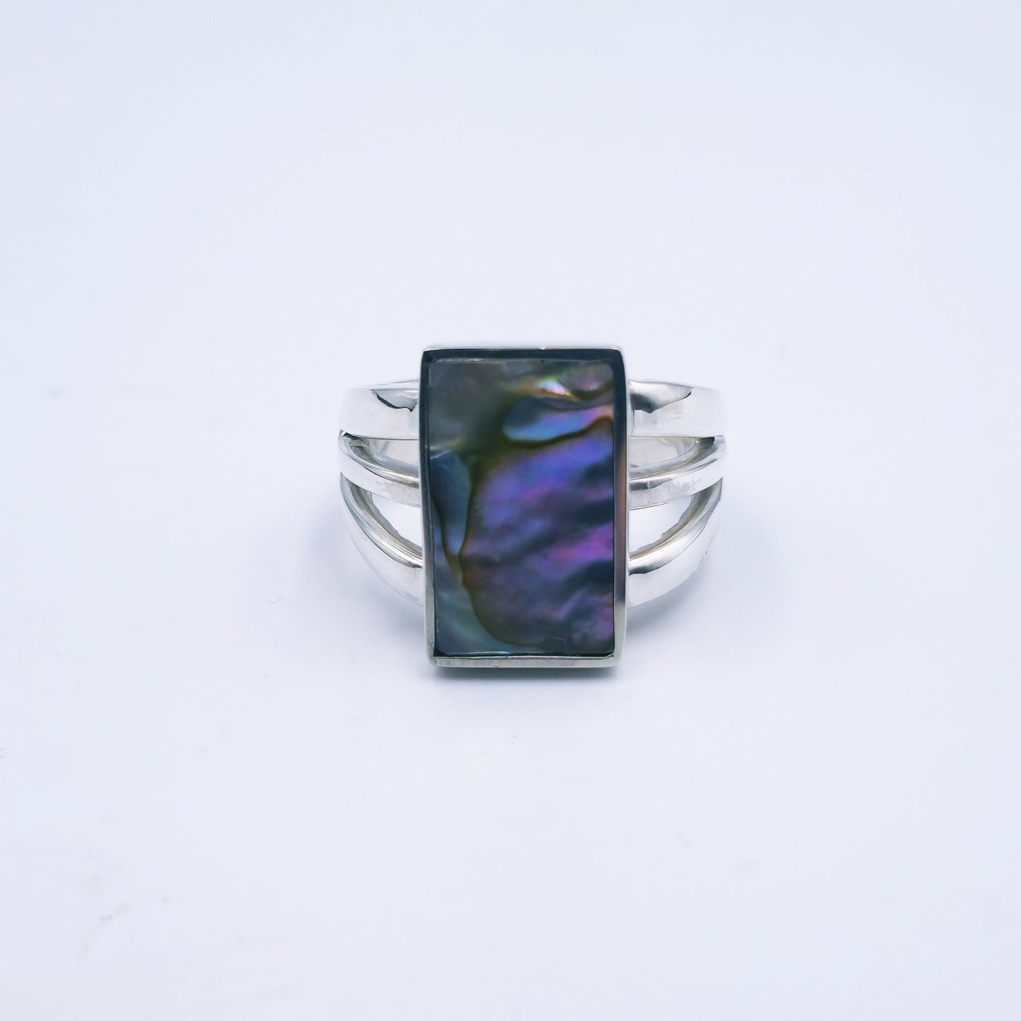 Three-band sterling silver ring featuring a rectangular abalone shell with rich iridescent tones, handmade and polished to a shine.