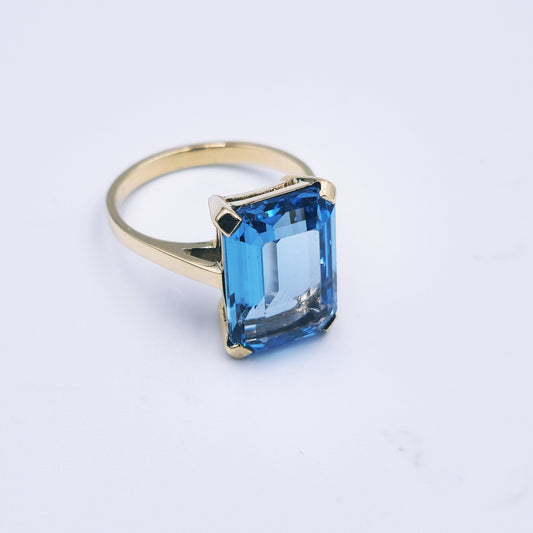 9ct yellow gold ring with a large emerald-cut blue topaz, classic and bold in style.