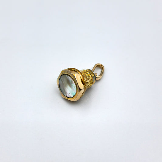 Restored 9ct yellow gold miniature fob seal pendant with curved scroll design and hexagonal base featuring a round mother of pearl inlay; approx. 14mm high x 10.5mm wide, 3.8g.