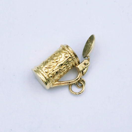 9ct yellow gold beer mug charm with floral design and hinged lid that opens; approx. 16.5mm high by 8mm wide, weighing 3.7g.