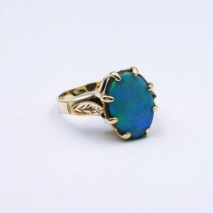9ct yellow gold ring featuring a 13.5mm x 10mm oval opal doublet in a claw setting with scalloped surround, ring size Q, approx. 4.4g.
