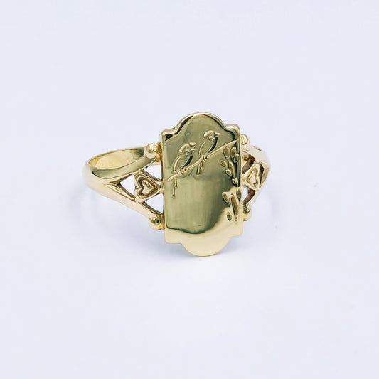 Traditional 9ct yellow gold signet ring with a 10mm scalloped disc engraved with a bird and two hearts, split shank design, ring size Q, approx. 2.3g.