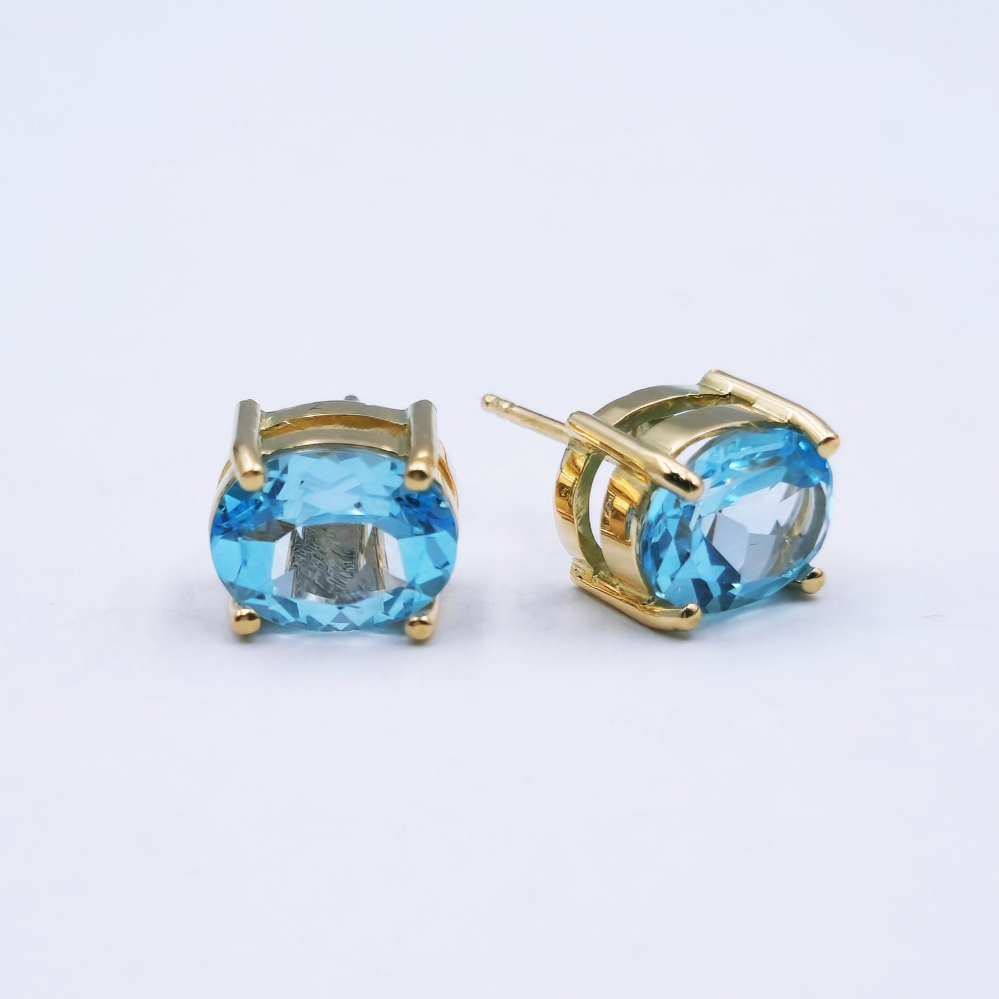 Pair of 9ct yellow gold stud earrings with large oval sky blue topaz (approx. 9mm x 7mm) in classic four-claw settings; approx. 2.5g total weight.