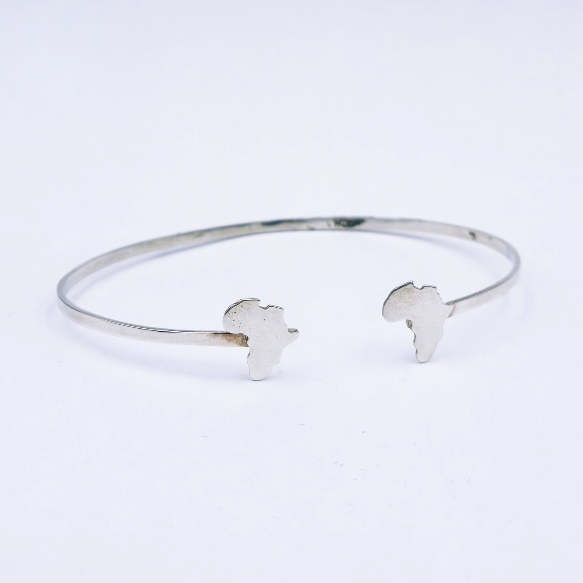 Sterling silver open bangle featuring cut-out Africa shapes at each end, 65mm adjustable diameter