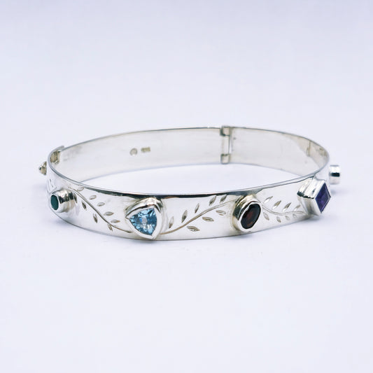 Repurposed vintage Scottish sterling silver bangle featuring a 15mm round light purple amethyst and Celtic detailing in a split band oval design.