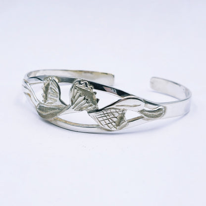 Silver bracelet with protea design on a white background