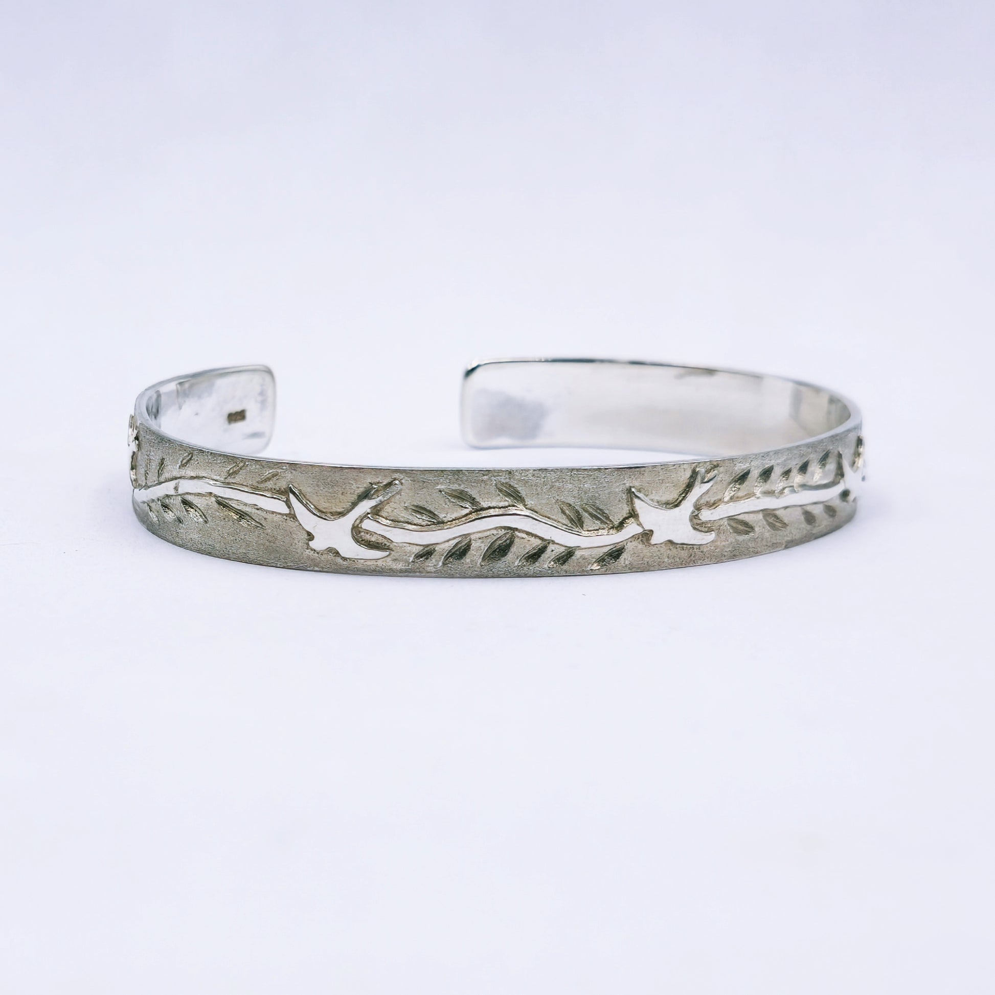 Sterling silver C-shape bangle featuring cut-out swallows and engraved leaves, handmade with 65mm diameter and 10mm width.