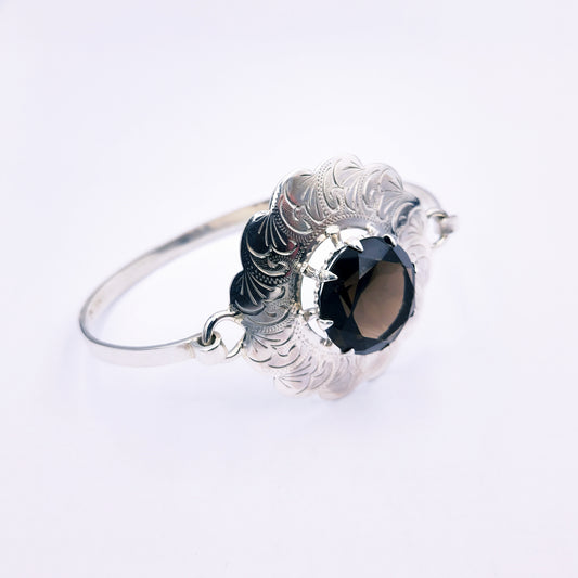 Sterling silver Celtic-style cuff bangle with a 43mm floral design, featuring a round 19mm smokey quartz gemstone at the centre and a clasp closure, weighing approximately 25.3g