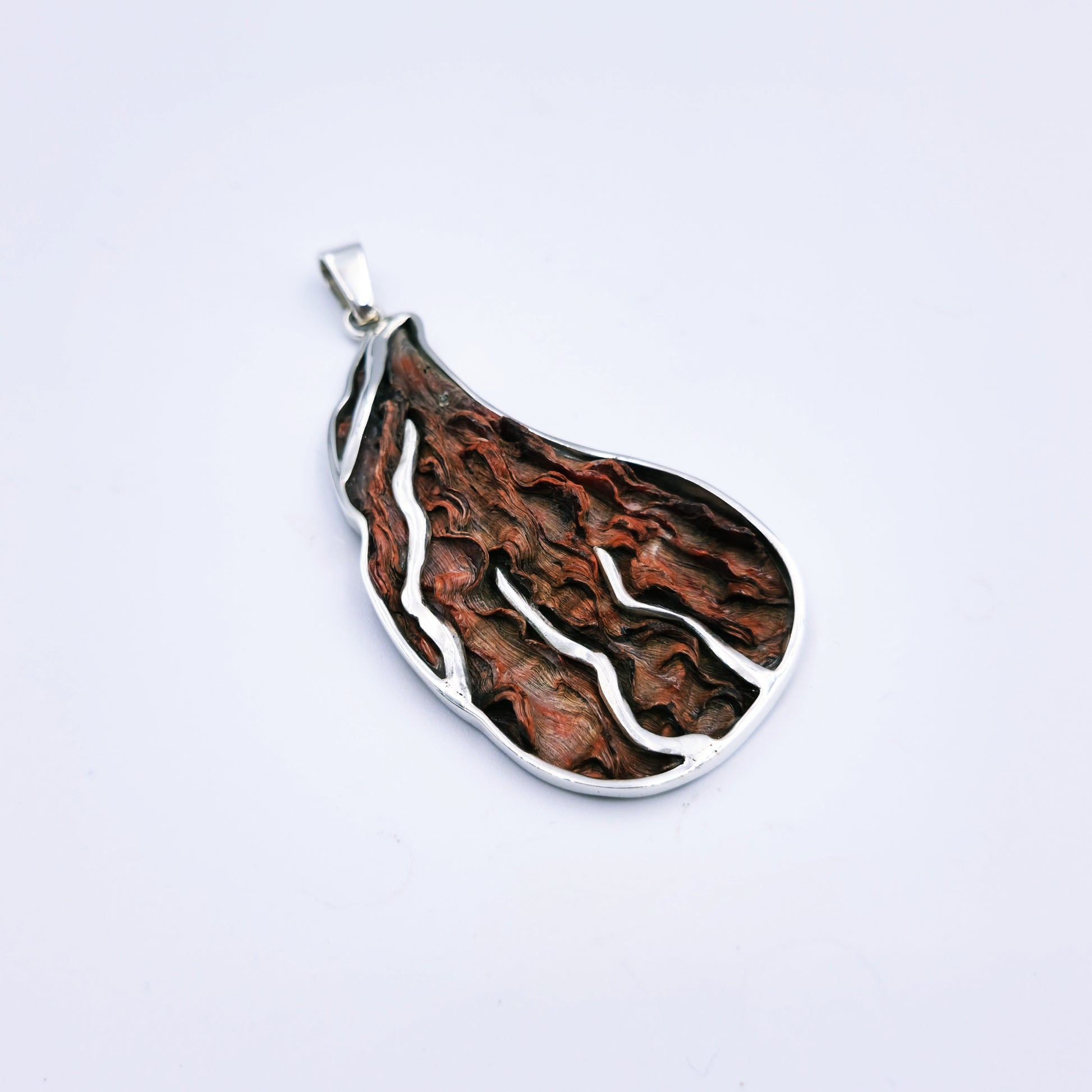 Free-form sterling silver pendant with natural abalone shell from the Eastern Cape, showing iridescent blues and greens with a silver frame.