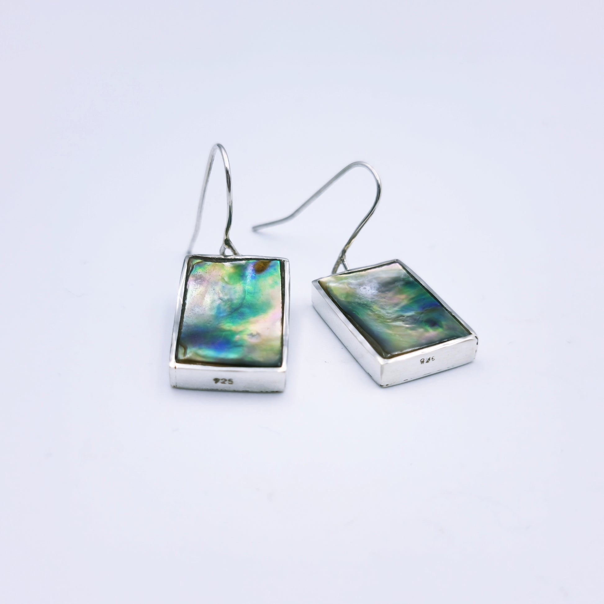 Free-form sterling silver pendant with natural abalone shell from the Eastern Cape, showing iridescent blues and greens with a silver frame.