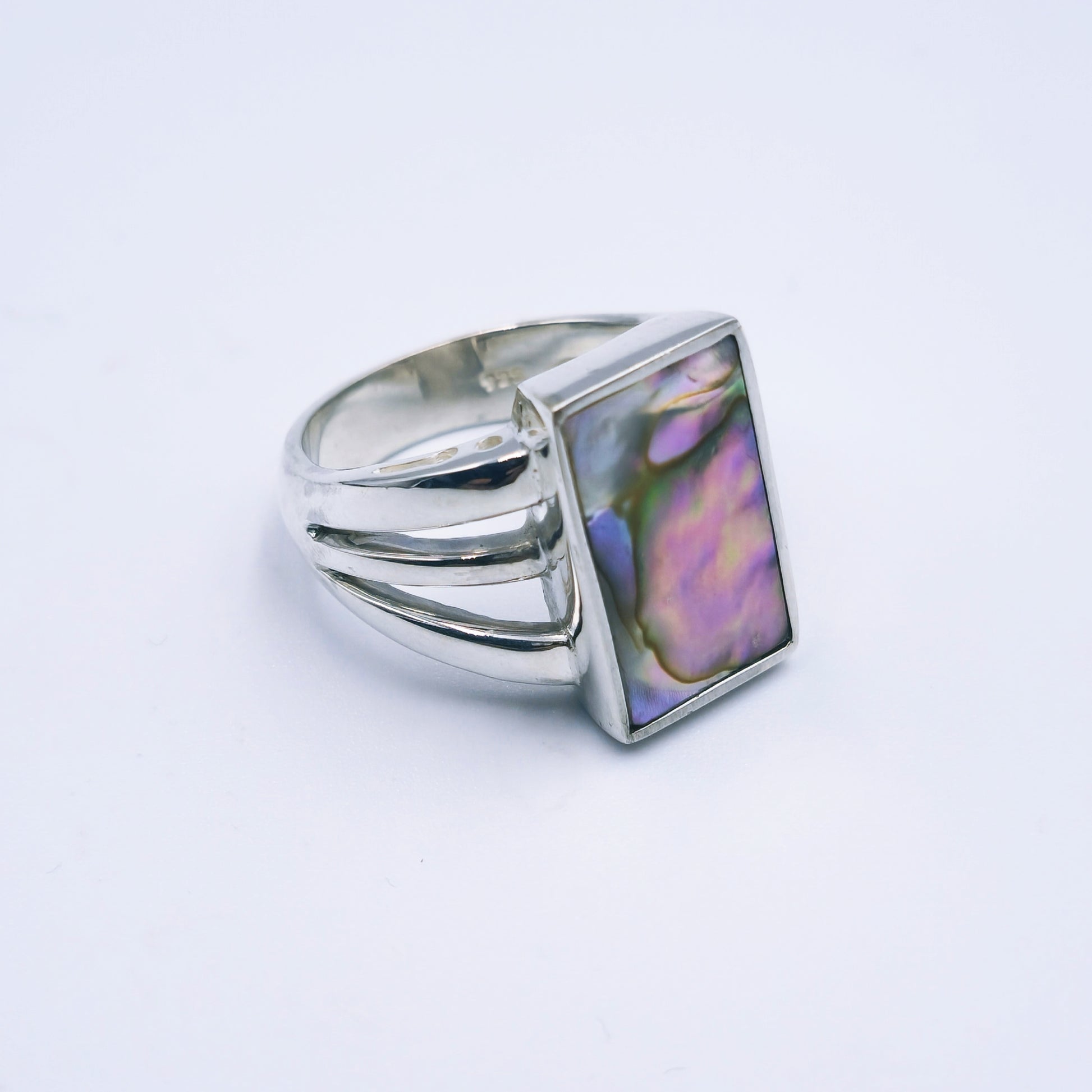 Three-band sterling silver ring featuring a rectangular abalone shell with rich iridescent tones, handmade and polished to a shine.
