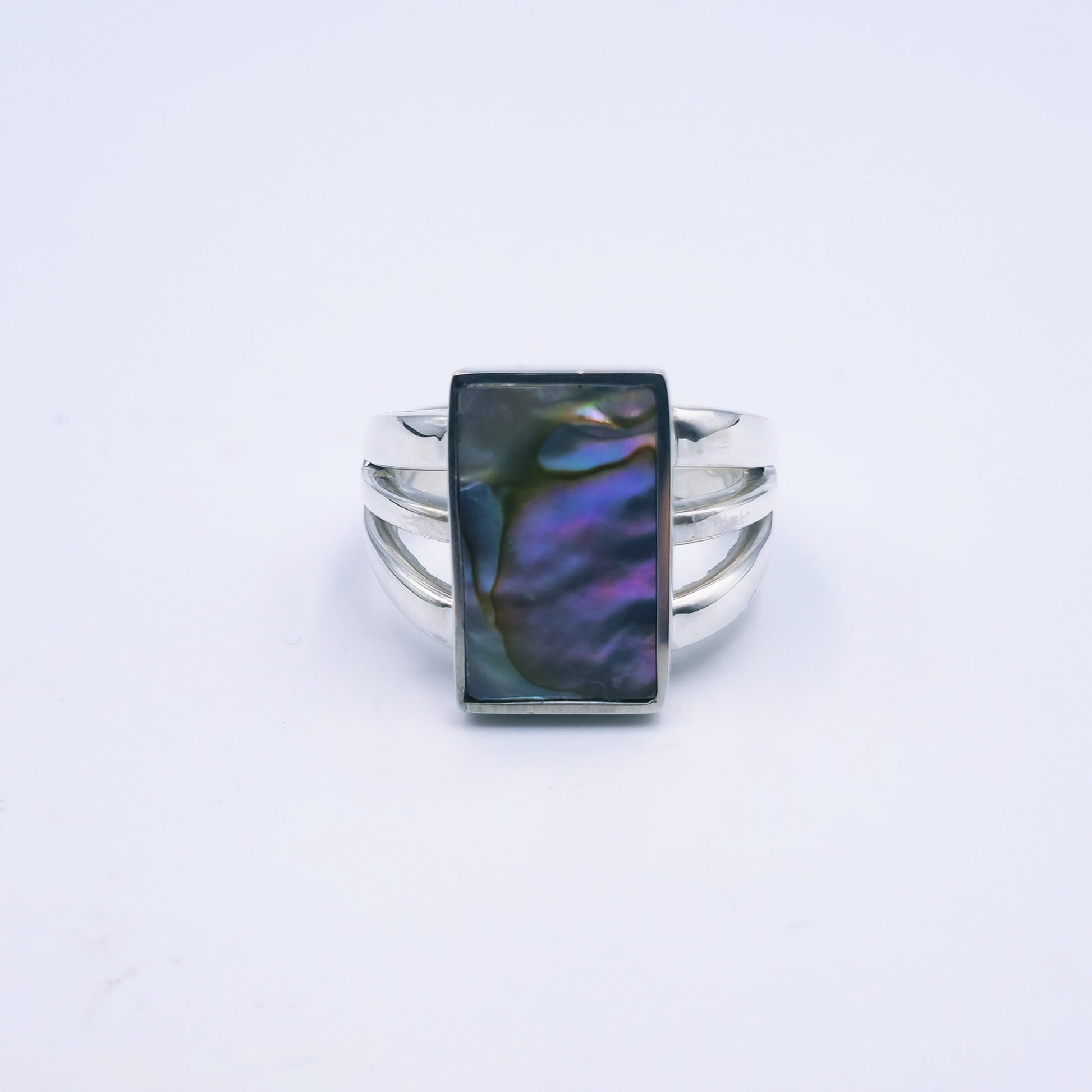 Three-band sterling silver ring featuring a rectangular abalone shell with rich iridescent tones, handmade and polished to a shine.