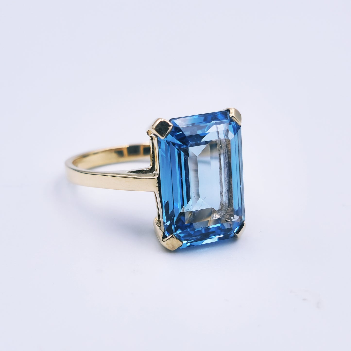 9ct yellow gold ring with a large emerald-cut blue topaz, classic and bold in style.